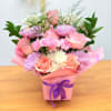 Pink and peach bouquet in a wrapped box with a purple ribbon