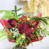 Bouquet of red roses with berries and greenery wrapped in red paper