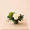 A fresh and organic flower arrangement featuring ivory roses, lush green accents