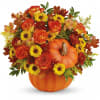 Autumn floral arrangement in a pumpkin container with orange roses and yellow daisies