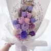 Bouquet of purple and pink roses wrapped in white paper