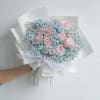 Bouquet of pink roses with blue baby's breath in white paper