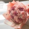 Pink and lavender rose bouquet wrapped in peach paper