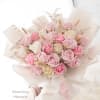 Bouquet of pink and white roses wrapped in pale paper
