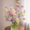 Pink and yellow flowers arranged in a clear glass vase