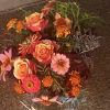A glowing celebration of coral roses, marigolds, and garden blooms gathered in