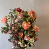 Coral Petal Garden is a sophisticated garden-style floral arrangement featuring premium seasonal