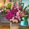 consiste en una caja de base color rosa la palabra happy birthday
