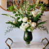White floral arrangement in a dark glass vase