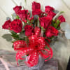 Bouquet of red roses in a glass vase with a red ribbon