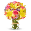 Bouquet of pink roses, yellow lilies, and purple daisies in a glass vase