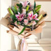 Bouquet of pink lilies and roses wrapped in beige paper