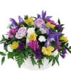 Mixed bouquet of roses, lilies, and carnations in a white basket