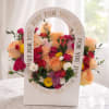 Mixed bouquet of peach roses, pink blooms, and yellow flowers in a white gift box