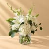 White lilies and hydrangeas in a clear glass vase