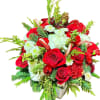 Red roses and white flowers in a vase with pine and ornaments