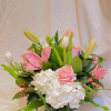 A soft and romantic garden-style floral arrangement featuring white hydrangeas, blush pink