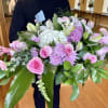 A graceful casket spray designed in soft shades of pink and white