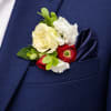 A compact cluster of white and pale yellow roses with red ranunculus-like