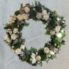 Heart-shaped floral wreath with white roses and green moss