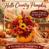 Autumn floral arrangement in a pumpkin container with bright fall flowers