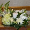 A classic all white arrangement with a candle placed amongst the blooms