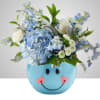 Blue hydrangeas, white roses, daisies and delphinium in a cheerful blue ceramic