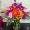 Mixed bouquet in a glass vase with a red gerbera daisy and pink roses