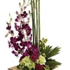 Tall orchid arrangement with bamboo and green hydrangeas in a wooden base