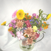 Rustic garden pitcher filled with spring blooms including Hydrangeas, Daisies Poms, Spray