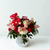 Bouquet of red and pink roses with a red teddy bear in a silver vase