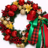 Christmas wreath with red and gold ornaments, reindeer figurines, and a large red and green bow