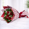 Bouquet of red roses wrapped in patterned paper with a red ribbon