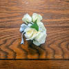 A cluster of white roses tied with a silver ribbon creates a