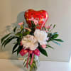Soft pink and white carnations paired with glossy green foliage create a
