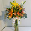 A tall, cheerful cluster of yellow lilies and warm orange-peach alstroemeria makes