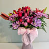 Hot pink roses and pink tulips take center stage in this vibrant