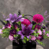 Purple lilies and chrysanthemums arranged in a black gift box with handles