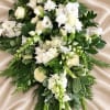 White floral spray with roses and snapdragons on a satin background