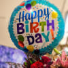 A bold round foil "Happy Birthday" balloon crowns this birthday flower arrangement