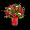 Red floral arrangement in a glass vase with a red ribbon