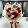 Red roses, pink carnations and white daisies with a graduation topper and