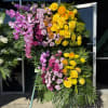 Large standing floral spray with yellow, pink, and purple flowers