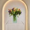 Mixed tulips with green accents in a clear rectangular vase-fresh, cheerful spring