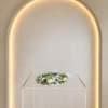 A delicate halo of baby's breath and cream-white roses with adjustable sizing.
For