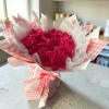 Bouquet of bright pink roses wrapped in pink gingham paper
