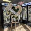 Heart-shaped floral wreath on an easel with a MOM sash