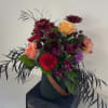 Mixed bouquet with roses and dark purple flowers in a vase