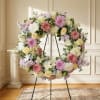 Pastel floral wreath on a black stand in a room