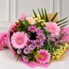 Bouquet of pink and purple daisies wrapped in brown paper and pink tissue